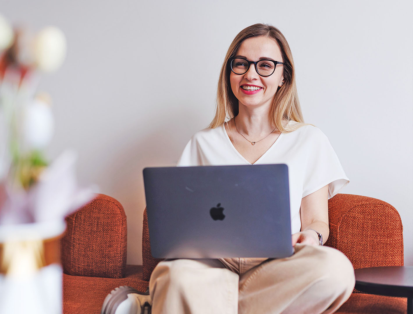 Smiling woman working on a laptop, representing Sombra's company statistics and data-driven approach.