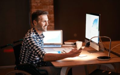 A man in a wheelchair sitting in front of a computer
