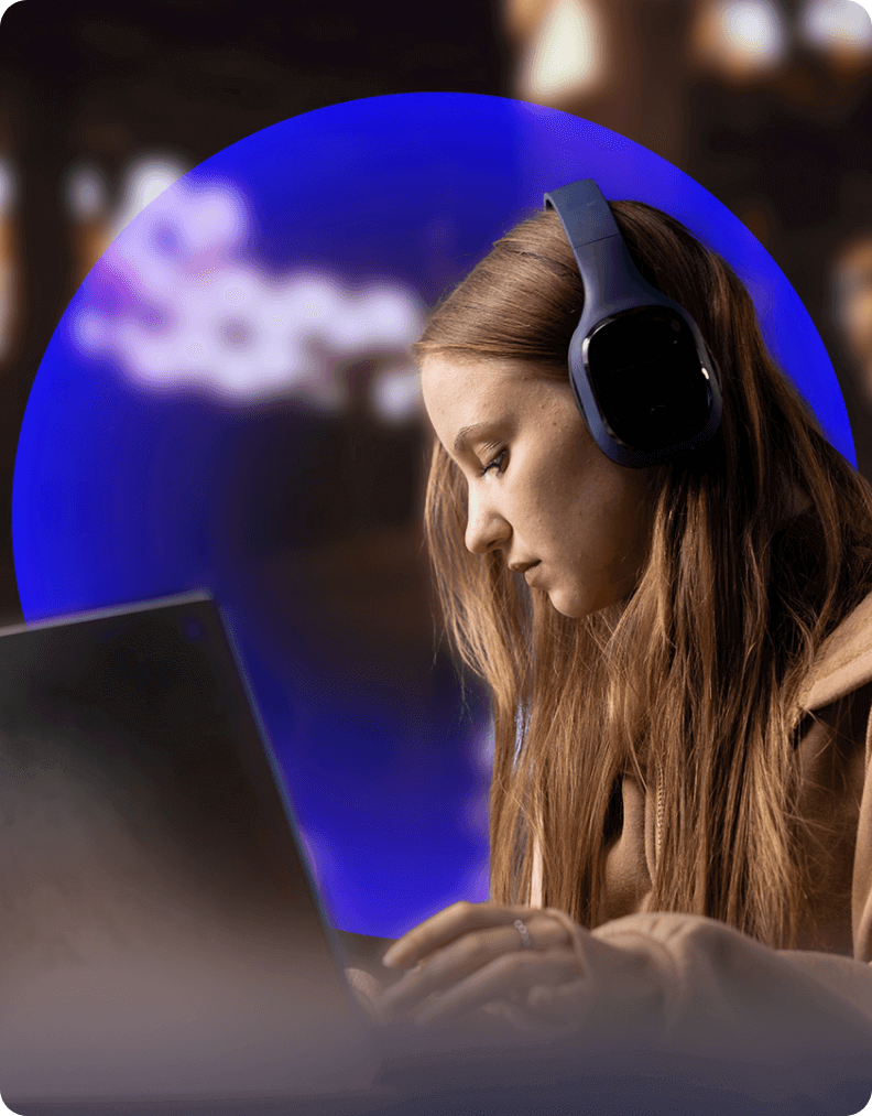 Female student learning online using a laptop and headphones, representing digital education.